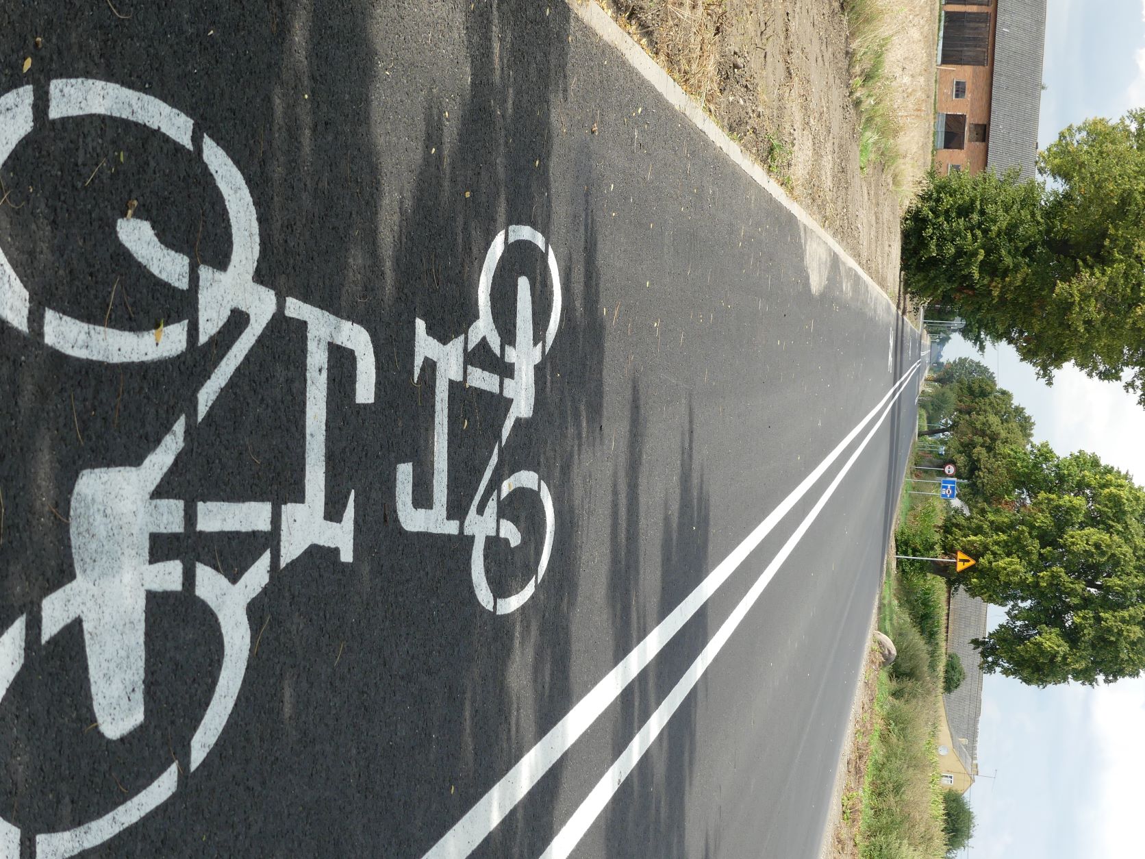 droga z narysowanymi znakami poziomymi ścieżka rowerowa